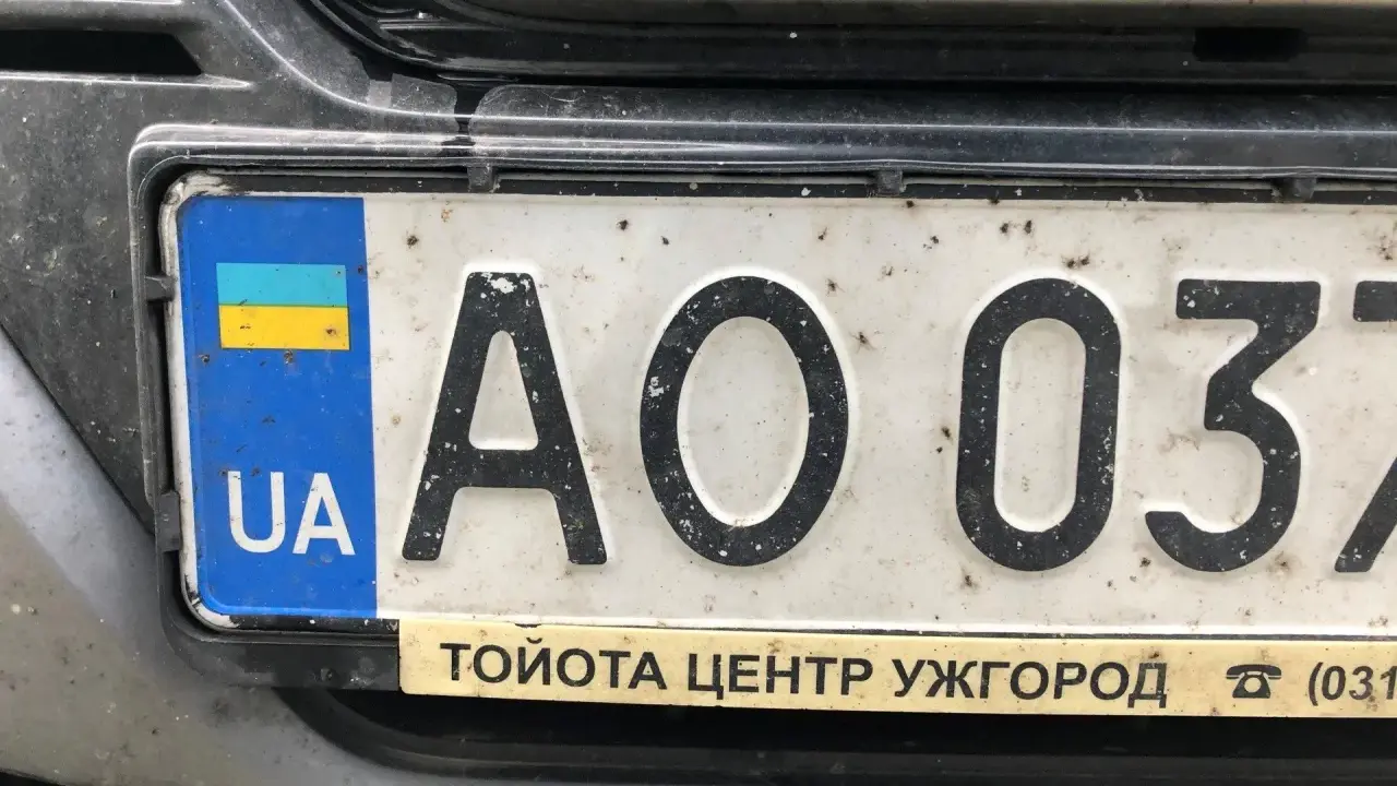 Ukraińskie tablice rejestracyjne z flagą i literami "UA" na białym tle. Widoczne cyfry "AO 037".