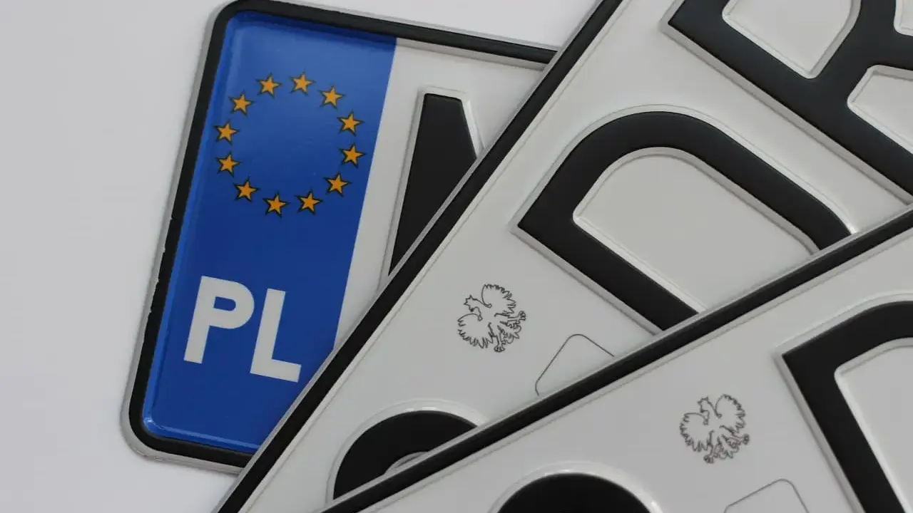 Kilka małych tablic rejestracyjnych, jedna z symbolem Unii Europejskiej i napisem PL, pozostałe z godłem Polski.