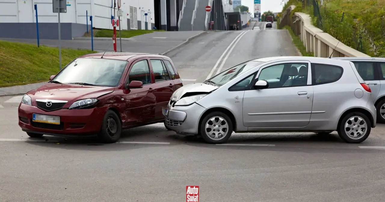 Wypadek samochodowy. Czerwone i srebrne auto po kolizji. Po takim zdarzeniu warto sprawdzić, jak sprawdzić ile mam zniżek na ubezpieczenie.