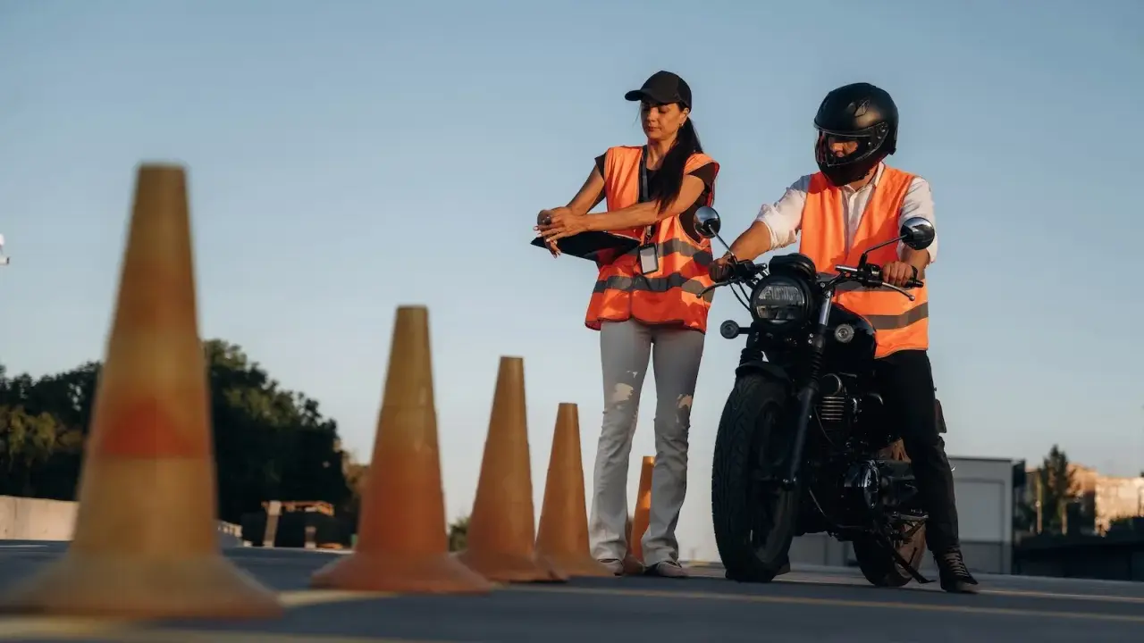 Instruktorka motocyklowa obserwuje kursanta podczas ćwiczeń na placu. Zastanawiasz się, ile godzin jazdy na kat. A potrzeba, by zdać egzamin?