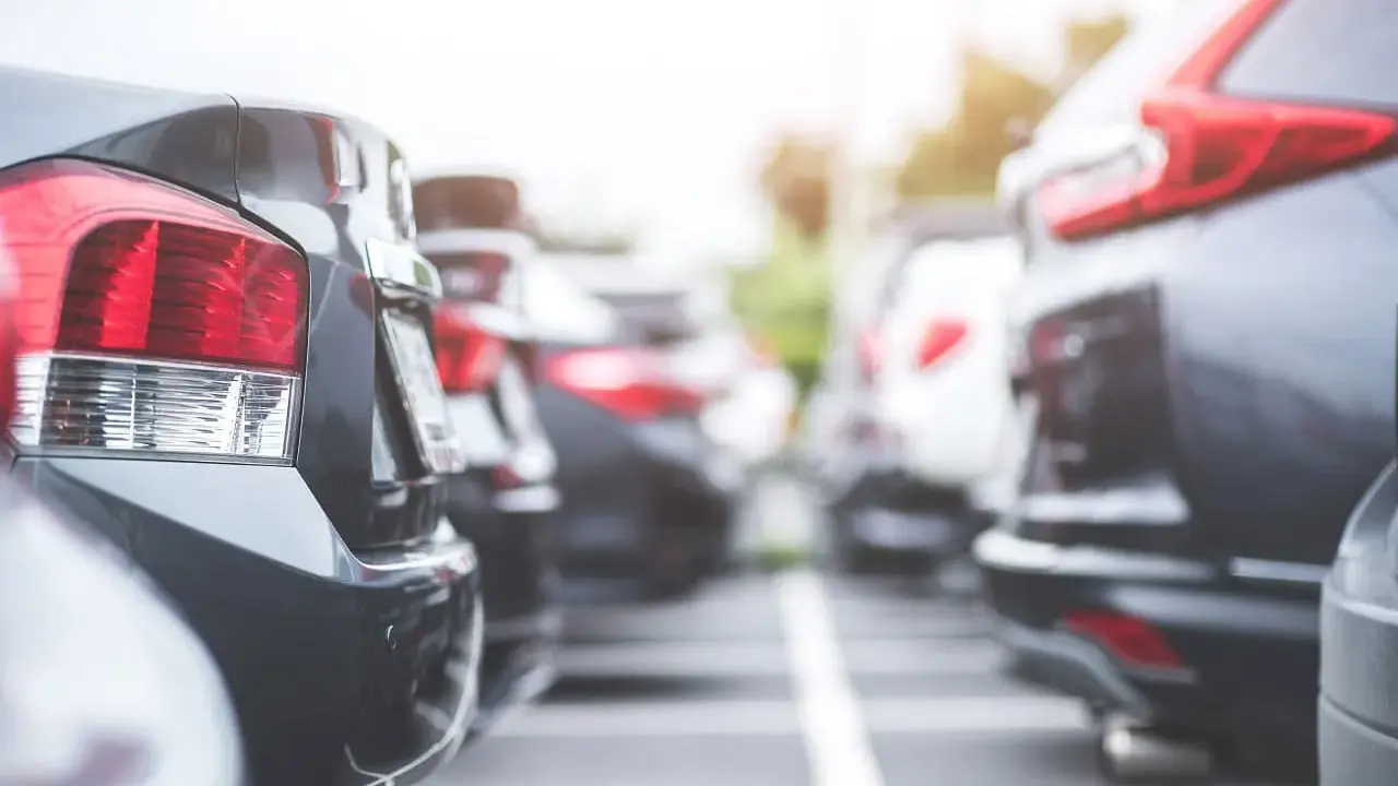 Rzędy samochodów na parkingu. Widać tylne światła i zderzaki. Czy to nowy oc?