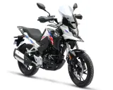 Biały motocykl z czerwono-niebieskimi akcentami, idealny na pierwsze wyprawy. Od ilu lat można robić prawo jazdy na motor 125? Od 16.