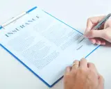 Dłoń podpisuje dokument ubezpieczeniowy. To ważny krok, być może wypowiedzenie OC.