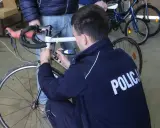 Policjant sprawdza rower, by ustalić, jak sprawdzić czy rower jest kradziony.