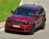 Czerwony Jeep Grand Cherokee z indywidualną tablicą rejestracyjną "S1 LNY" na torze wyścigowym.