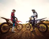 Dwóch motocyklistów w pełnym rynsztunku na motocyklach crossowych. Czy na crossa trzeba mieć prawo jazdy? To pytanie zadaje sobie wielu pasjonatów.