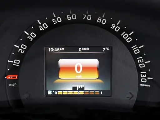 Wyświetlacz samochodu po wymianie licznika: 0 mph, 10:45, 7°C. Wskaźnik paliwa i bieg P/E.