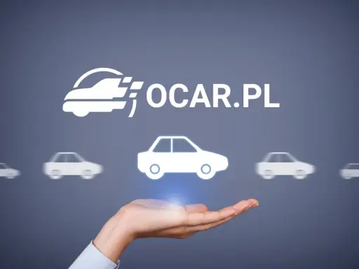 Dłoń trzyma symbol samochodu, nad którym widnieje logo OCAR.PL. To miejsce, gdzie znajdziesz ogólne warunki ubezpieczenia.