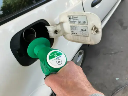 Tankowanie auta. Pistolet z zieloną końcówką, oznaczony jako "euro super Pb E5", jest wkładany do wlewu paliwa. Na klapce wlewu widnieje napis "Diesel".