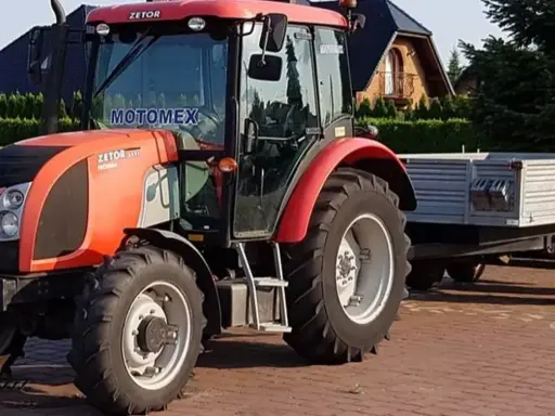 Czerwony Zetor z przyczepą, gotowy do pracy. Marzenie o własnym polu i prawo jazdy na traktor staje się rzeczywistością.