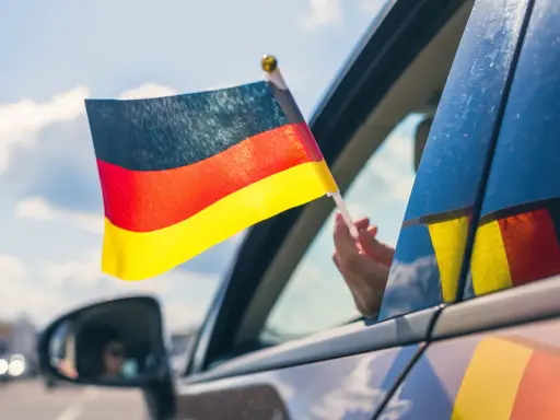 Niemiecka flaga powiewa z okna samochodu. To jak raport TUV z podróży, pełen dumy i radości.
