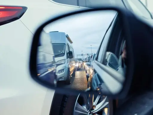 Korek na drodze, w lusterku widać kampera. Czy hamowanie silnikiem jest szkodliwe? Zastanawiamy się, stojąc w korku.