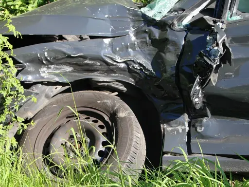 Zniszczony samochód po wypadku, z powyginaną karoserią i pękniętą szybą. Ciekawe, jakie zniżki AC po ilu latach można uzyskać po takiej przygodzie.