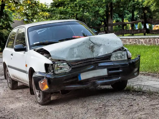Uszkodzony biały samochód po wypadku. Zastanawiasz się ufg co to? To ubezpieczeniowy fundusz gwarancyjny, który pomaga w takich sytuacjach.