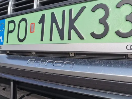 Czy trzeba mieć tablice rejestracyjne przy rejestracji? Na zdjęciu widać tablicę z numerem PO 1NK33 na samochodzie Audi e-tron.