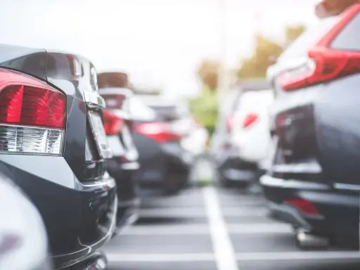 Rzędy samochodów na parkingu. Widać tylne światła i zderzaki. Czy to nowy oc?