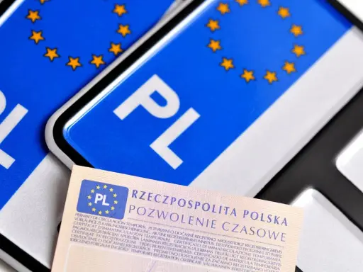Tablice profesjonalne z symbolem PL i gwiazdkami Unii Europejskiej, obok dokumentu "Pozwolenie Czasowe".