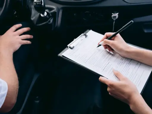 Kobieta wypełnia formularz podczas rejestracji samochodu przez dealera.