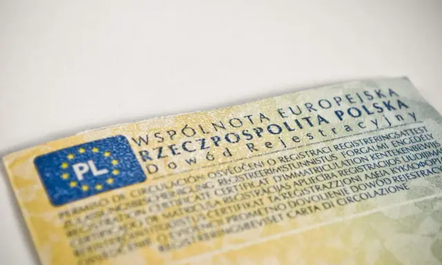Dowód rejestracyjny pojazdu, niezbędny do ubezpieczenia samochodu, z flagą PL i tekstem w wielu językach.