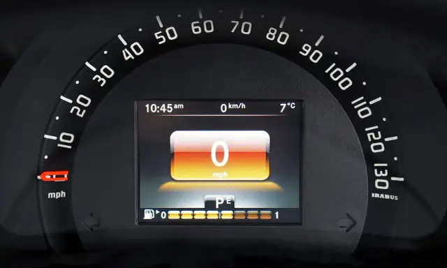 Wyświetlacz samochodu po wymianie licznika: 0 mph, 10:45, 7°C. Wskaźnik paliwa i bieg P/E.