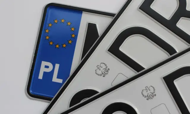 Kilka małych tablic rejestracyjnych, jedna z symbolem Unii Europejskiej i napisem PL, pozostałe z godłem Polski.