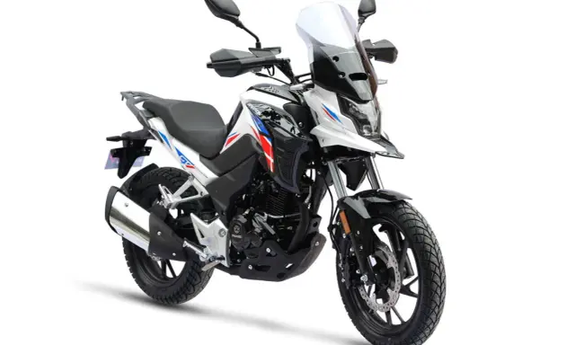Biały motocykl z czerwono-niebieskimi akcentami, idealny na pierwsze wyprawy. Od ilu lat można robić prawo jazdy na motor 125? Od 16.