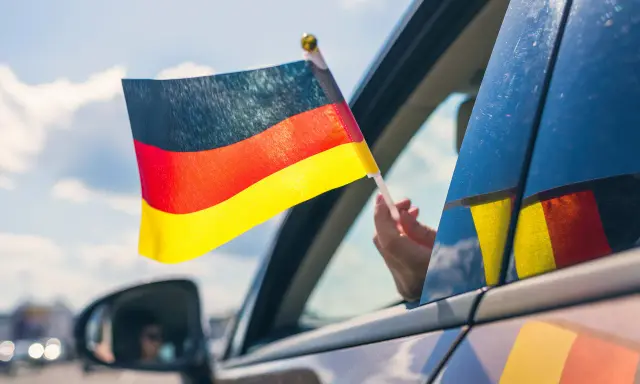 Niemiecka flaga powiewa z okna samochodu. To jak raport TUV z podróży, pełen dumy i radości.