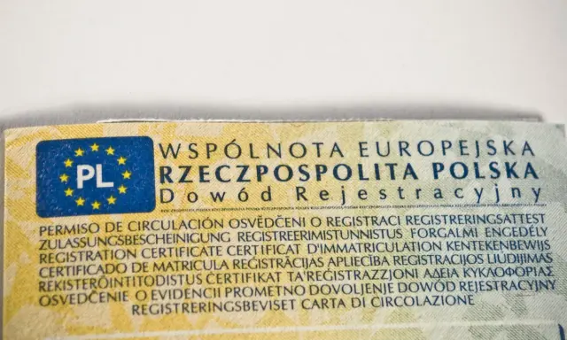 Fragment dowodu rejestracyjnego pojazdu z oznaczeniem PL i tekstem w wielu językach. Widać fragment numeru VIN w dowodzie.