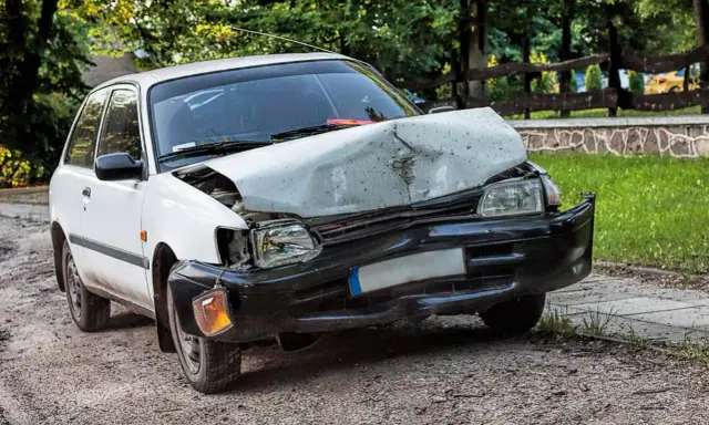 Uszkodzony biały samochód po wypadku. Zastanawiasz się ufg co to? To ubezpieczeniowy fundusz gwarancyjny, który pomaga w takich sytuacjach.