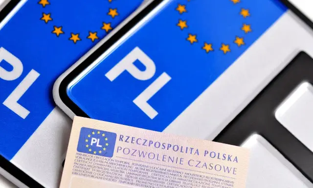 Tablice profesjonalne z symbolem PL i gwiazdkami Unii Europejskiej, obok dokumentu "Pozwolenie Czasowe".