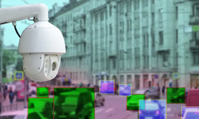 Kamera monitoringu miejskiego rejestruje ruch uliczny. Kolorowe ramki wskazują wykryte obiekty, potencjalnie do wystawienia mandatu z monitoringu miejskiego.