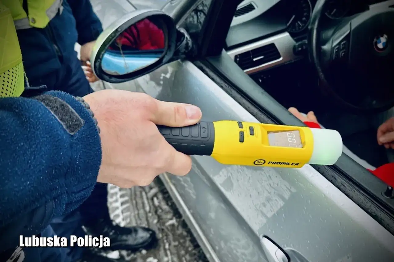Policjant bada trzeźwość kierowcy alkomatem. Wynik 0.00 promila. Pamiętaj, że powyżej 0.5 promila jaka kara jest surowa.