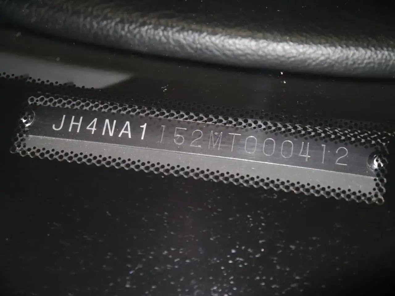 Numer VIN JH4NA1152MT000412 wybity na metalowej tabliczce.
