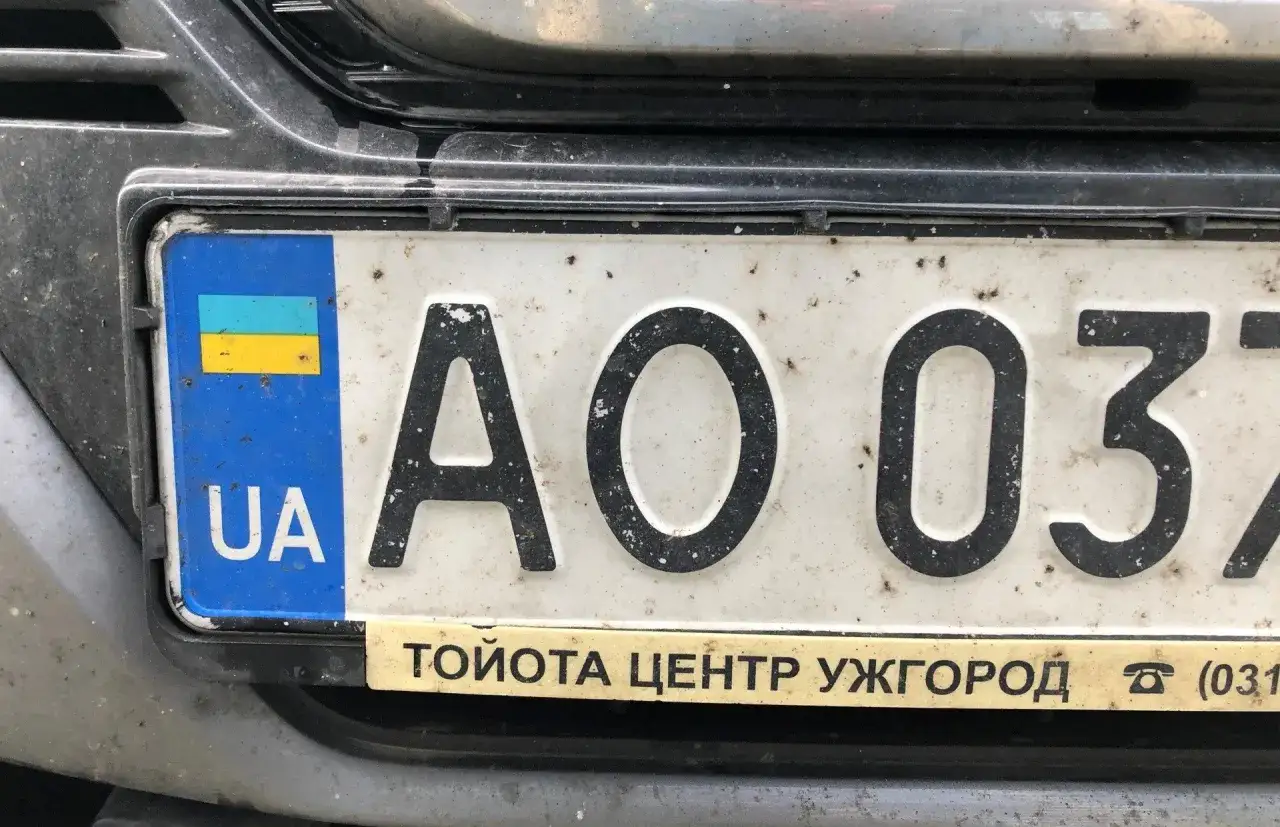 Ukraińskie tablice rejestracyjne z symbolem UA i numerem AO 037. Pod spodem napis 