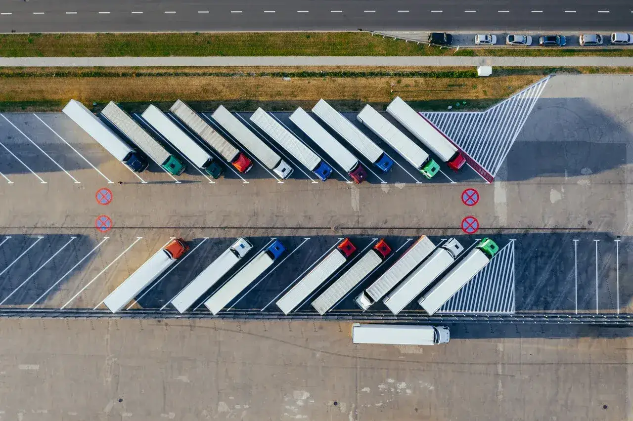 Wielki parking z rzędami ciężar&oacute;wek, idealne miejsce do zdobycia prawa jazdy na tira.