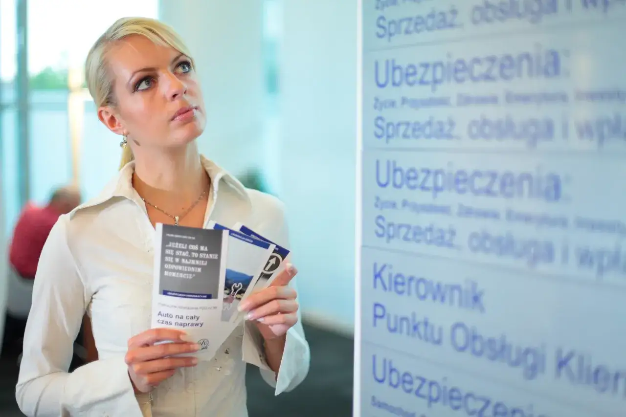 Kobieta z ulotkami zastanawia się nad ofertą ubezpieczenia. Czy podwójne ubezpieczenie OC to dobry wybór?