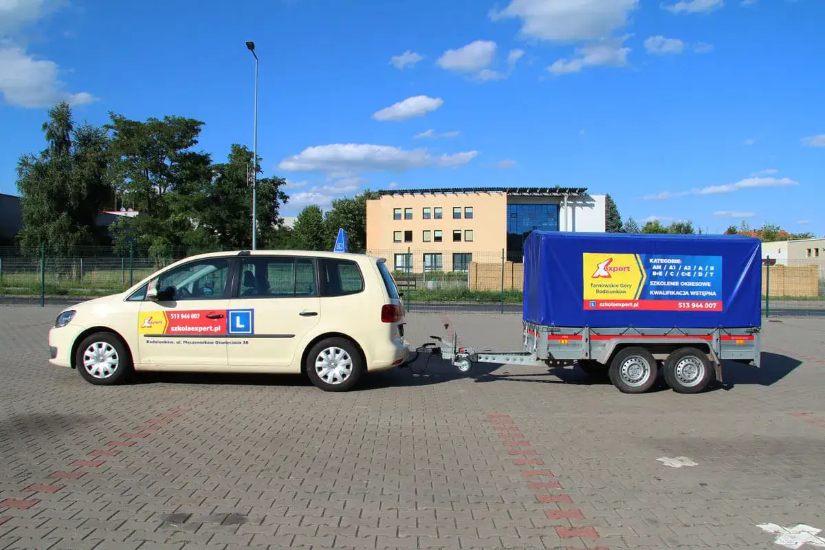 Samoch&oacute;d z przyczepą, nauka jazdy z prawem jazdy B+E czym można jeździć. Na przyczepie logo szkoły jazdy.